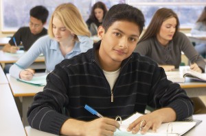 Male Hispanic student taking notes